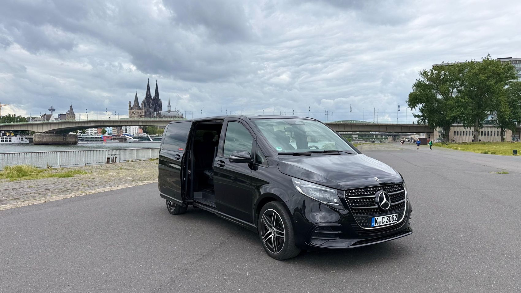 Schwarze Mercedes-Benz V-Klasse am Rheinufer vor dem Kölner Dom